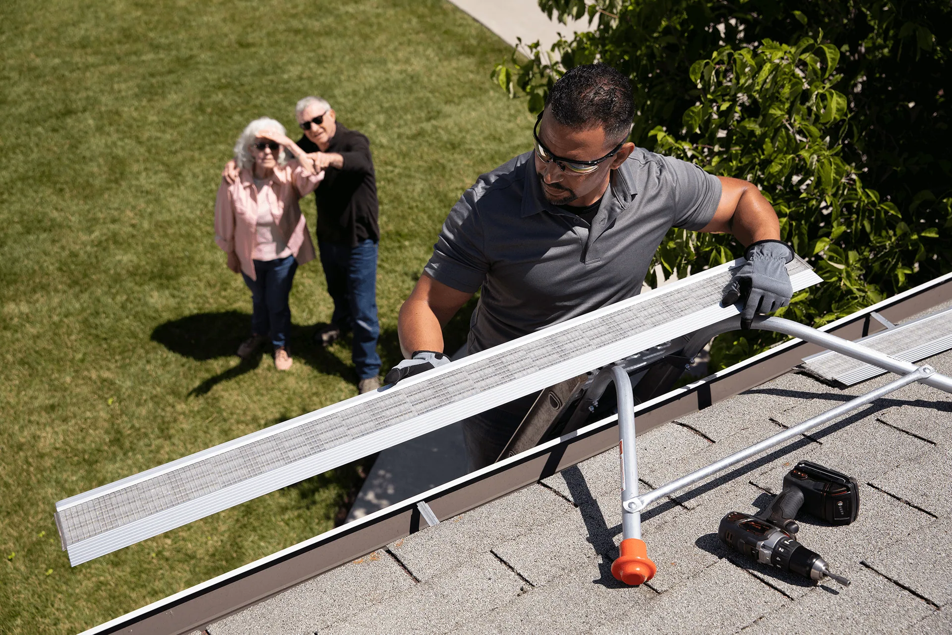 Installer carrying mesh gutter guard homeowners watching, Sanford FL